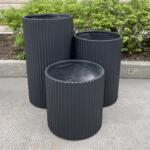 Fluted Cylinder Garden Pots with colorful annuals and small shrubs, suited for outdoor use.