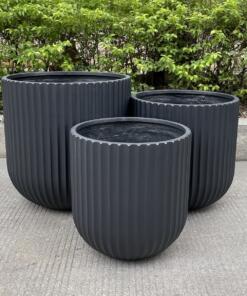 A collection of Fluted Garden Tubs in different sizes and colors, showcasing their ribbed design. These tubs are ideal for enhancing both indoor and outdoor spaces.