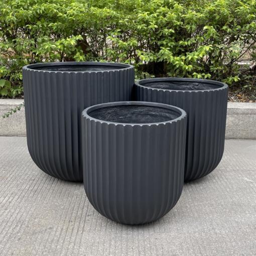 A collection of Fluted Garden Tubs in different sizes and colors, showcasing their ribbed design. These tubs are ideal for enhancing both indoor and outdoor spaces.